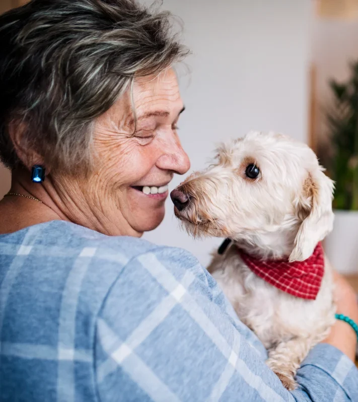 woman with pet dog in lap while she is on her laptop