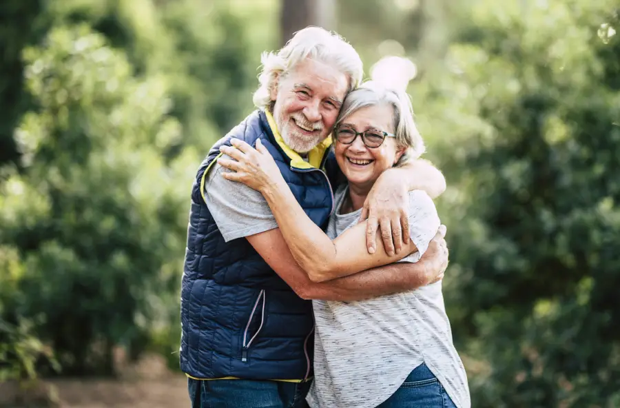 Happy senior couple holding each other outdoors.