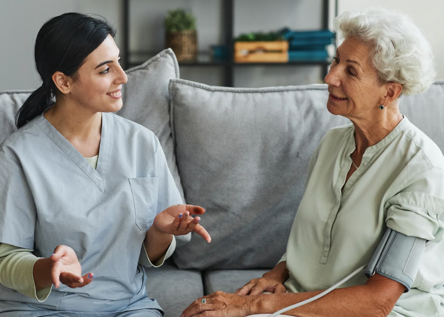 Young nurse talking to senior woman.